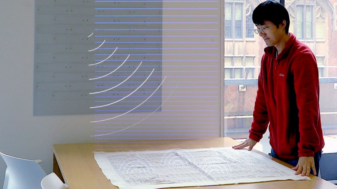 Nanfang Yu examining a knitted textile metasurface